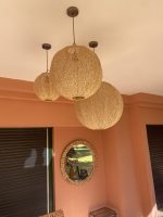 Handmade Moroccan raffia globe pendant light with elongated oval woven shape