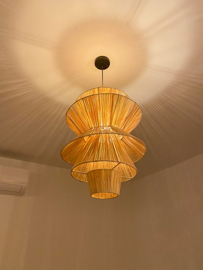 Handmade tiered raffia pendant light with layered sculptural design