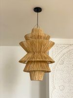 Handmade tiered raffia pendant light with layered sculptural design
