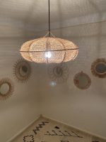 Sculptural Raffia Pendant Light handmade from natural woven raffia with a structured metal frame.