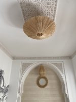 Natural raffia flush mount ceiling light with round handwoven sunburst design and metal frame.