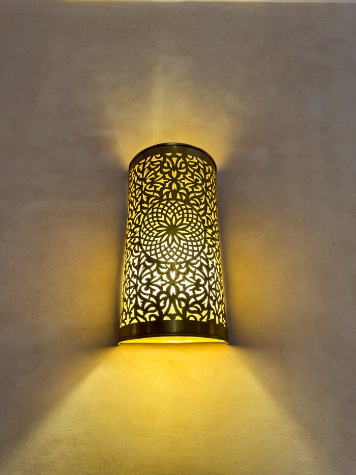 Handmade Moroccan brass wall sconce crafted from solid brass with intricate pierced detailing and warm up-and-down decorative illumination.