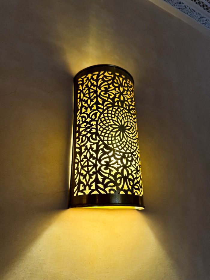 Handmade Moroccan brass wall sconce crafted from solid brass with intricate pierced detailing and warm up-and-down decorative illumination.