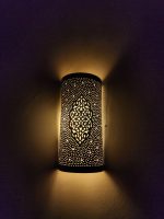 Handmade Moroccan pierced brass wall lamp with perforated pattern and warm up and down lighting.