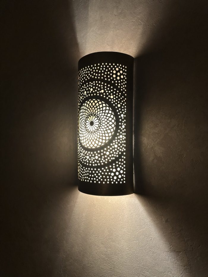 Handmade radiant rosette brass wall sconce with central geometric floral medallion and pierced decorative pattern.