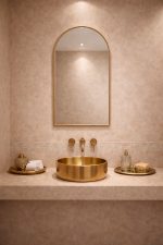 Handmade arched brass wall mirror with slim gold brass frame displayed above a bathroom vanity.