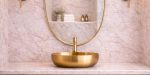 Curved Shield Brass Mirror displayed above entryway console with slim brass frame
