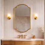 Crown Curve Brass Mirror above wood vanity with green tiled bathroom wall