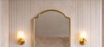 Crown Curve Brass Mirror above wood vanity with green tiled bathroom wall