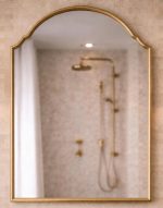 Arched Brass Mirror with curved brass frame above a bathroom vanity