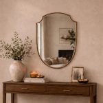 Curved Shield Brass Mirror displayed above entryway console with slim brass frame