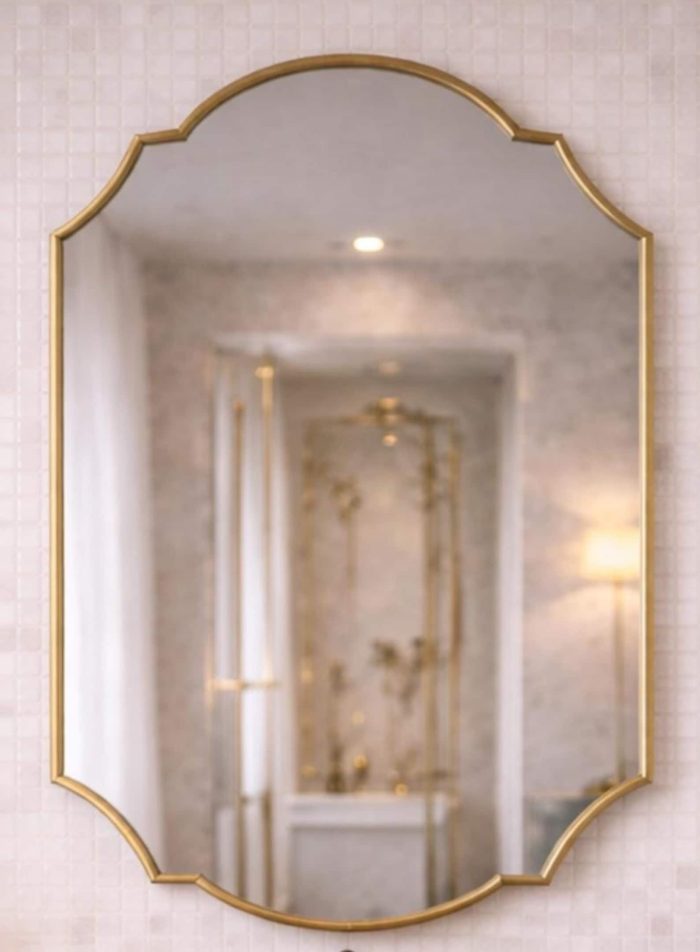 Handmade Double Crest Brass Mirror above stone vessel sink and wooden vanity