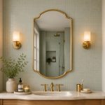 Crown Curve Brass Mirror above wood vanity with green tiled bathroom wall