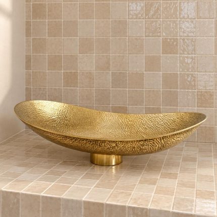 Hand hammered brass vessel sink with elongated oval shape and textured golden finish